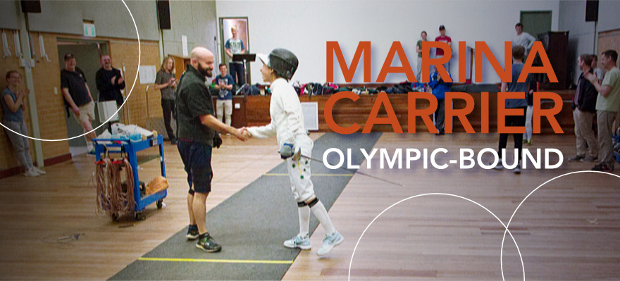 Marina Carrier and coach Jo Raciborski shake hands on the piste after a bout at the MFC training venue. Some members and spectators stand at the sides applauding and smiling. This bout was pretty dynamic! I think we all know who won that one. Sorry Joe, you may have amazing calves but Marina is small and mighty! Forza Marina!